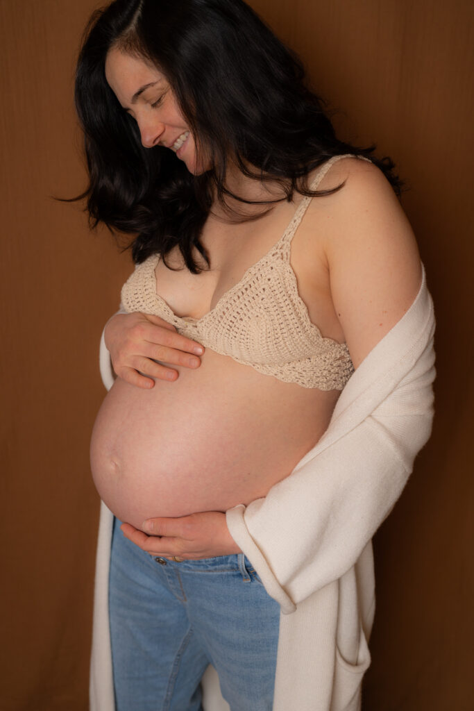 photographe professionnel Limoges -femme enceinte qui se caresse le ventre chez son photographe à lIMOGES