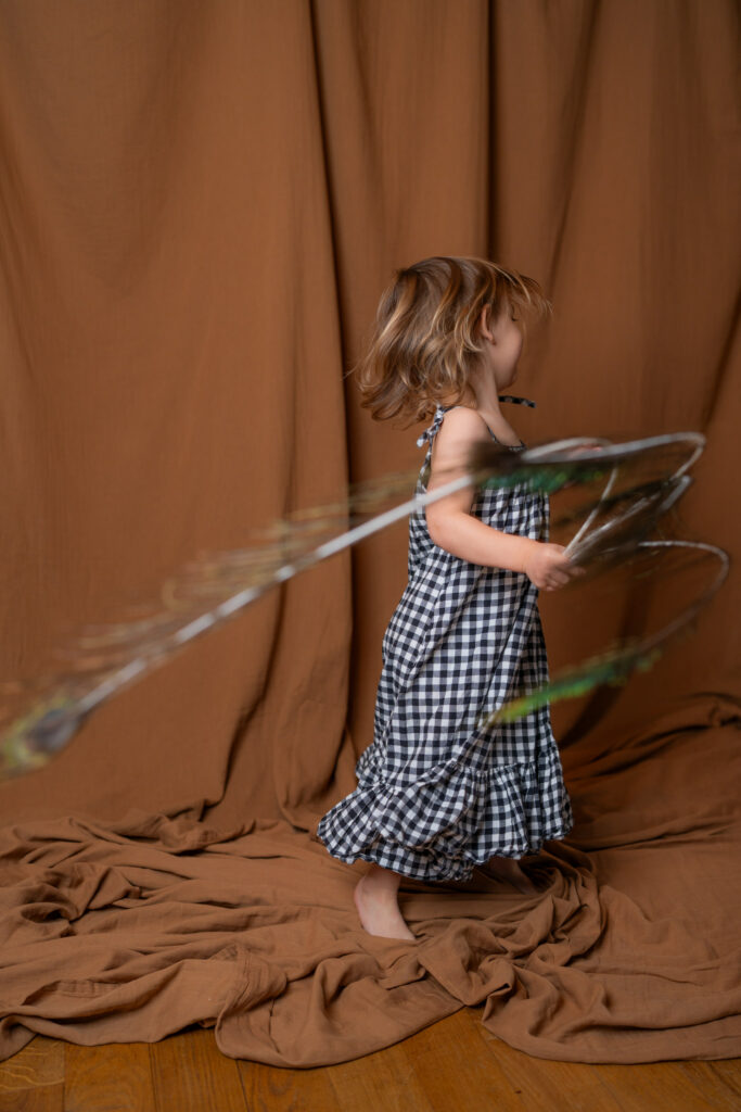 Photographe à Limoges -petite fille qui danse avec une plume de paon