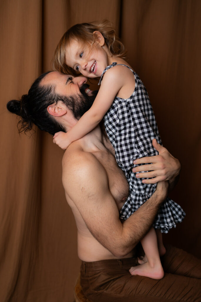 Photographe à Limoges -Photo d'un papa et de sa fille qui se câlinent et rigolent au studio photo